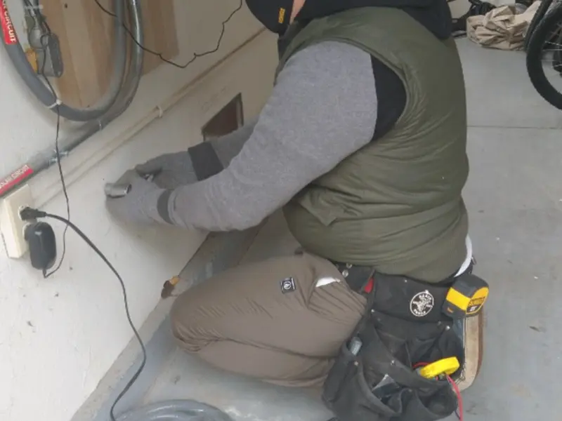 Electrician performing outlet wiring in a Rio Rancho garage